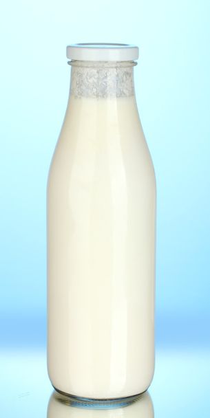 Bottle of milk on blue background close-up - Fotoğraf, Görsel