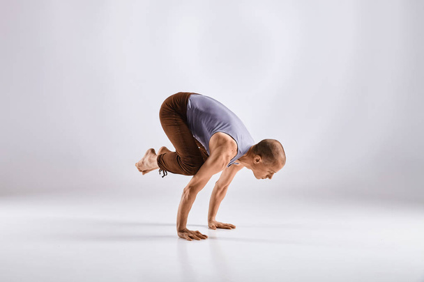 Uomo che fa yoga isolato su sfondo bianco
 - Foto, immagini