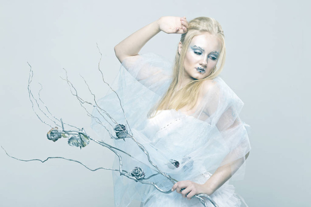 Ξανθιά σε λευκό φόρεμα με μπλε μακιγιάζ. Η βασίλισσα του χιονιού. - Φωτογραφία, εικόνα