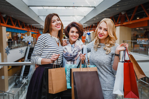 Grupo de mujeres jóvenes con bolsas de compras en el centro comercial, decoradas para Navidad
 - Foto, imagen