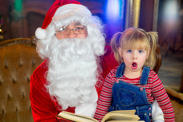 Santa Claus and girls reading a book - Фото, зображення