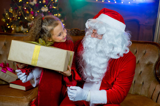 Santa Claus y niña con regalos de Navidad
 - Foto, Imagen