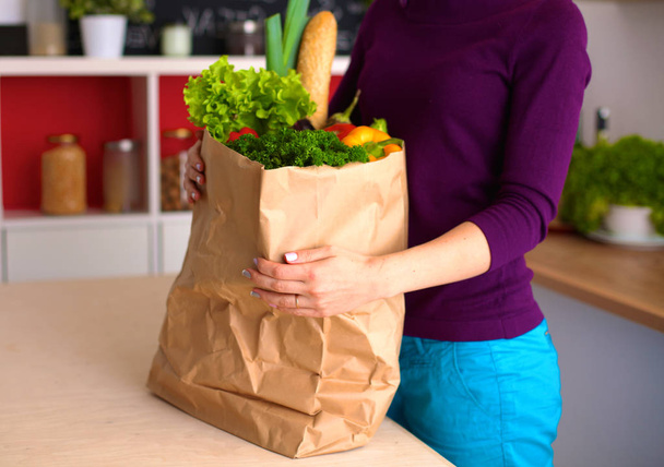 Mulher feliz positivo saudável segurando um saco de compras de papel cheio de frutas e legumes
 - Foto, Imagem