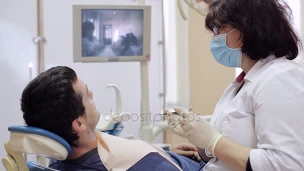 Dentist checks teeth of male patient by dental mirror - Imágenes, Vídeo