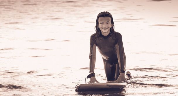дівчина вдягнена з гідрокостюмом з дошкою для тіла
 - Фото, зображення