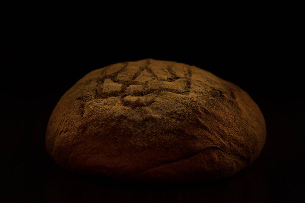 Loaf of wheat bread on rustic background. Urraine emblem - Foto, Imagen
