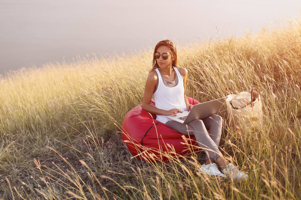 Hipster freelancer woman works outdoors in meadow - Фото, зображення