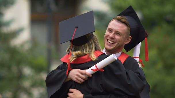 Счастливые университетские друзья тепло обнимаются, поздравляют с выпускным
 - Кадры, видео