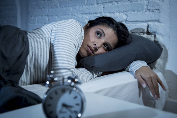 hiszpanin Kobieta w domu sypialnia leżąc w łóżku, późno w nocy, starając się snu bezsenność cierpienia - Zdjęcie, obraz