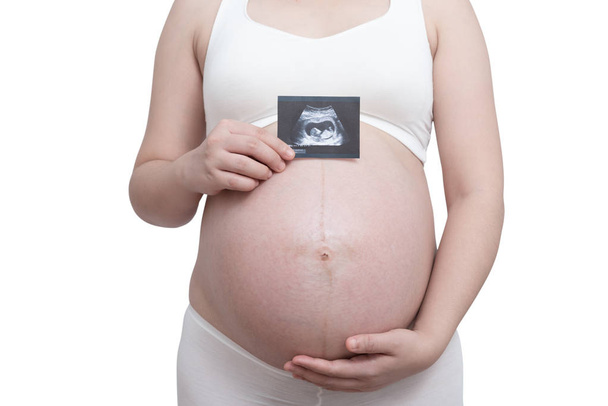 La mujer embarazada del vientre asiática sosteniendo su vientre aislado sobre fondo blanco - Foto, Imagen