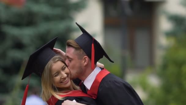 Jonge man en vrouw verliefd zijn afstuderen aan de Universiteit, zoenen en knuffelen - Video
