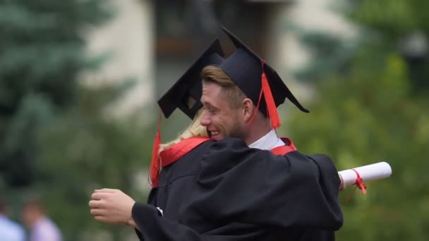 Amis masculins et féminins embrassant, détenant des diplômes d'enseignement supérieur dans les mains
 - Séquence, vidéo