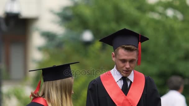 Αστεία αρσενικό απόφοιτος κάνοντας ουρλιάζοντας πρόσωπο, κρατώντας πανεπιστημιακών πτυχίων στα χέρια - Πλάνα, βίντεο