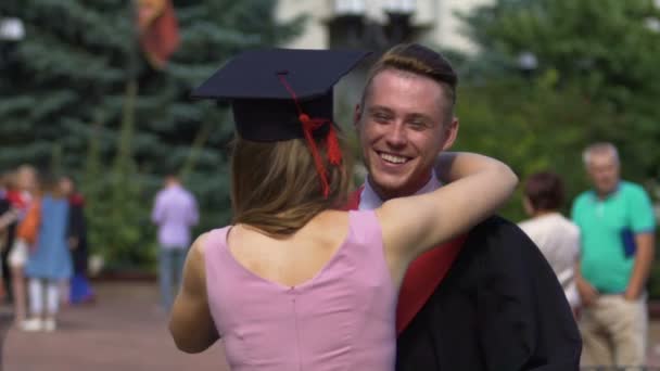 Young lady congratulating successful graduating student, friends hugging warmly - Footage, Video