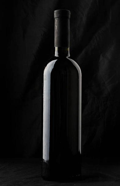 Wine bottle silhouette isolated on black background - 写真・画像