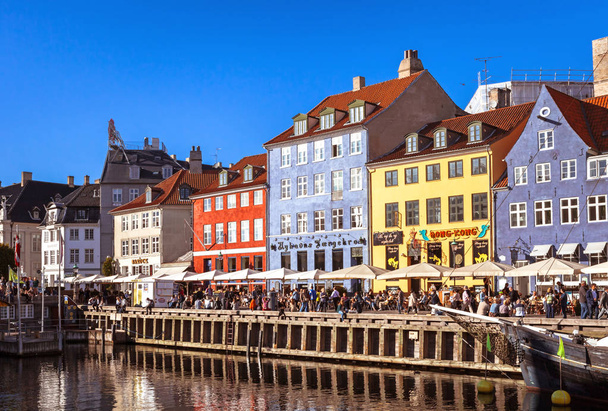 COPENHAGEN, DENMARK - SEPTEMBER 9: people in open cafes of the famous Nyhavn promenade on September 9, 2016 in Copenhagen, Denmark. Nyhavn is one of the most famous landmark of Copenhagen. - Φωτογραφία, εικόνα