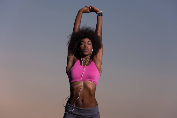 mulher negra está fazendo alongamento exercício relaxante e aquecimento
 - Foto, Imagem