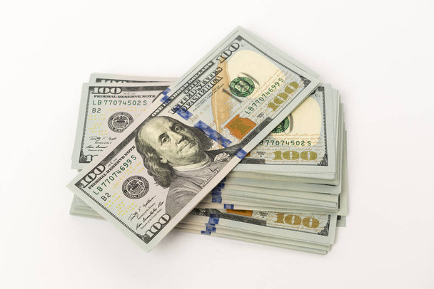 Montón de billetes nuevos de cien dólares en la superficie blanca
 - Foto, Imagen