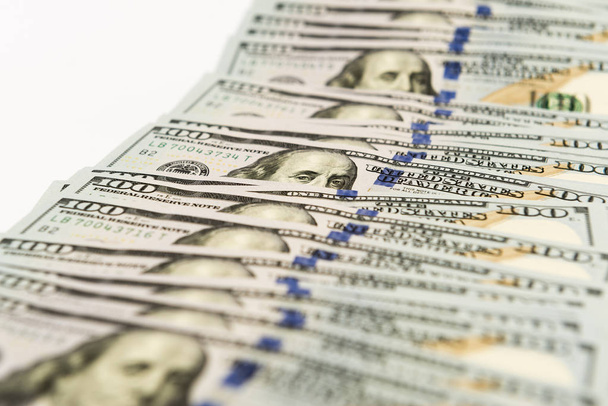 Банкноты стоимостью в сто долларов разбросаны по белой поверхности
 - Фото, изображение