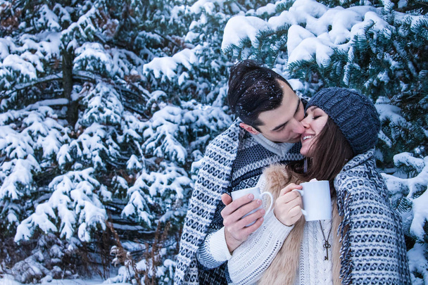 Couple hugs and kisses in winter forest - Photo, Image
