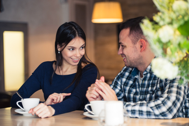 Young couple talking in coffee shop - Fotó, kép