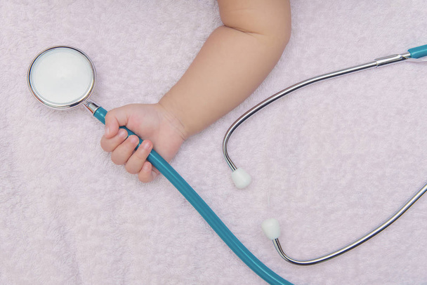 medical instruments stethoscope in hand of newborn baby girl - Fotó, kép