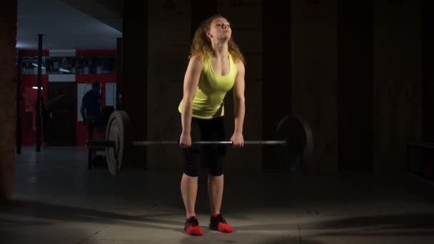Young woman doing deadlifts with a barbell in the gym. - Filmagem, Vídeo