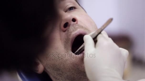 The dentist puts a cotton ball near the patients tooth. - Metraje, vídeo