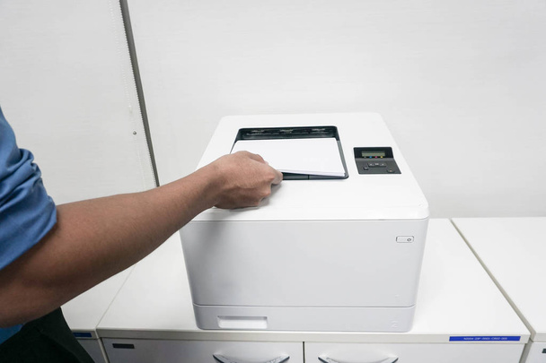 επιχειρηματίας με φύλλο χαρτιού στο μηχάνημα εκτυπωτή γραφείου - Φωτογραφία, εικόνα