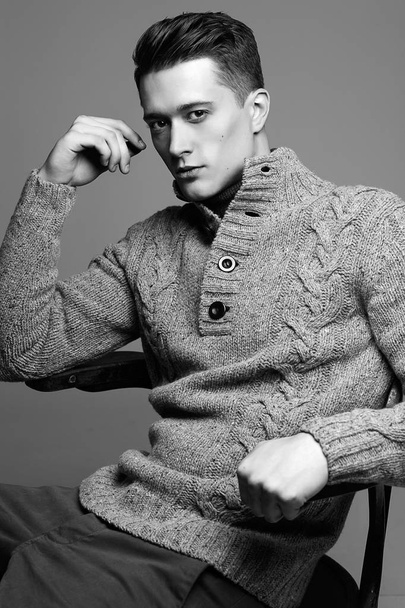 Sexy young man in warm knit sweateron a gray background . Male model.  - Fotografie, Obrázek