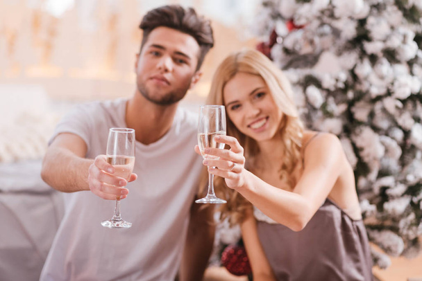 Delighted joyful couple holding glasses of champagne - Foto, imagen