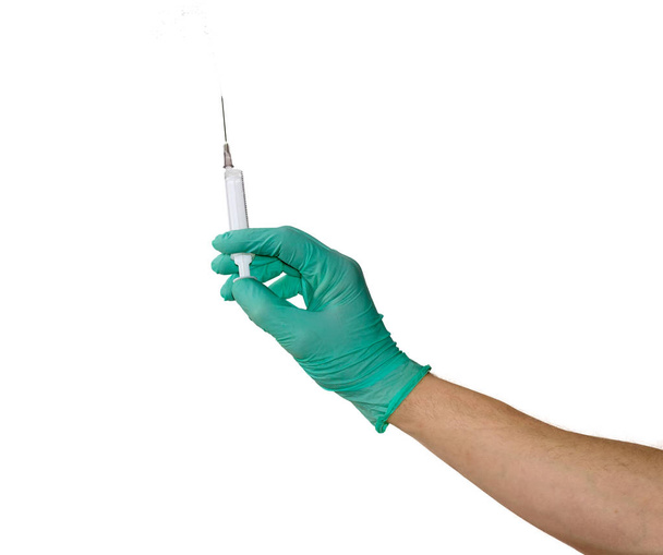 Медицинский шприц в мужской руке в медицинской перчатке
 - Фото, изображение