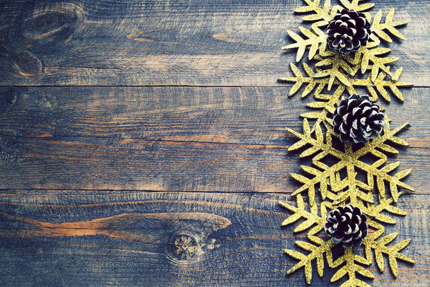 Christmas wooden background with decorative snowflakes and pine cones. Snowflakes on a wooden board.  - Fotografie, Obrázek