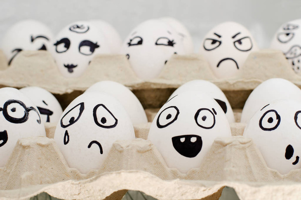 Huevos en bandeja pintados con diferentes emociones: tristeza, sorpresa, asombro. Primer plano
 - Foto, Imagen