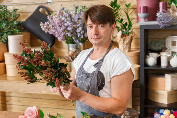 フラワー ショップ配信で男の花屋アシスタントがブーケを作る - 写真・画像