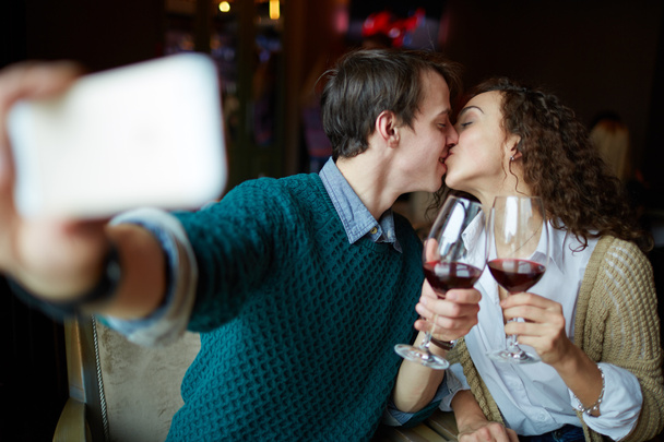 Young man kissing his wife in restaurant - Photo, Image