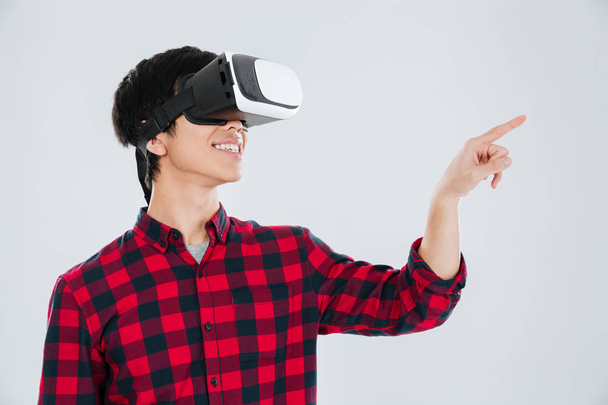 Man wearing virtual reality device and pointing right - Foto, Imagen