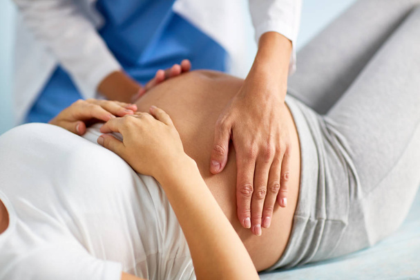 obstetra tocando barriga de mulher grávida
 - Foto, Imagem