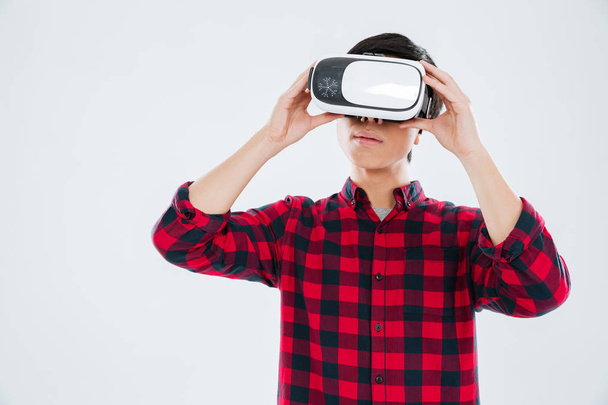 Young asian man wearing virtual reality device - Foto, imagen