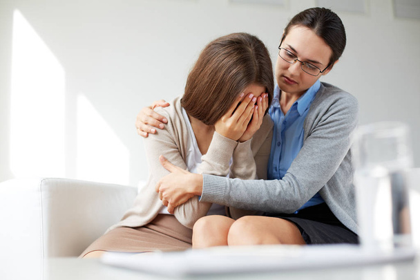 girl weeping while psychologist embracing her - Фото, зображення
