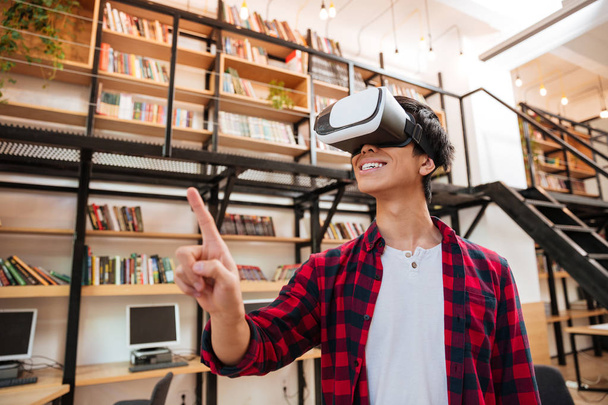 Man wearing virtual reality device in the library - Fotoğraf, Görsel