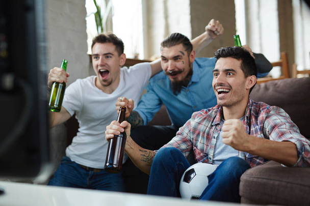 парни сидят перед телевизором
  - Фото, изображение