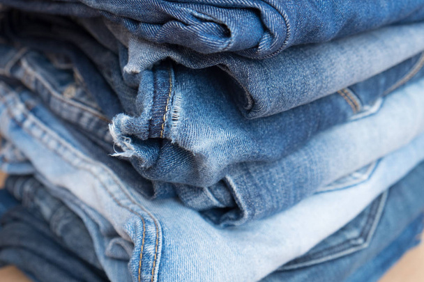 Stapel blauwe jeans broek in een winkel - Foto, afbeelding