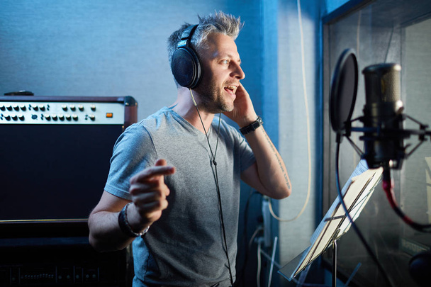 мужчина исполняет свои песни в студии пластинок
  - Фото, изображение