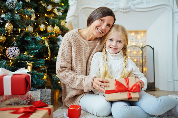 girl and her grandmother with xmas gifts  - Фото, зображення