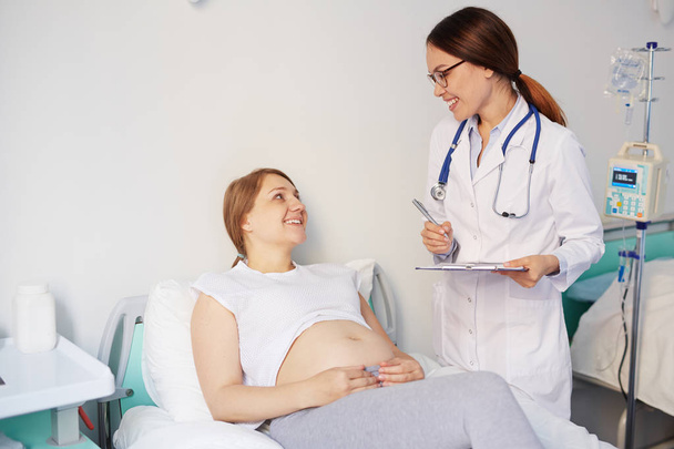 врач консультирует ее беременную пациентку
  - Фото, изображение