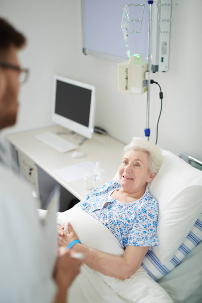Пожилая пациентка разговаривает со своим врачом
 - Фото, изображение