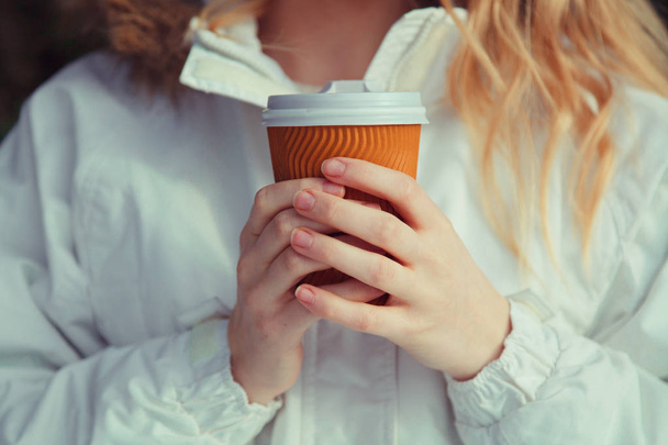 orange braune Tasse mit weißem Deckel innen gefüllt mit heißem Tee oder Kaffee.  - Foto, Bild