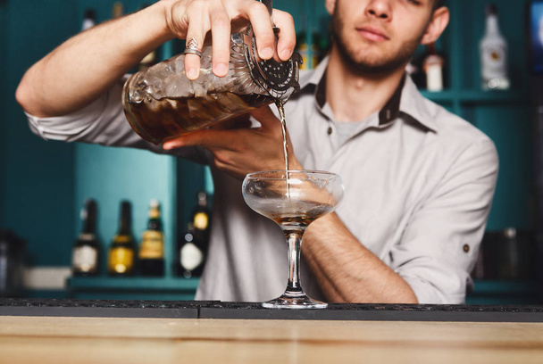 Young Barman mengen kosmopolitische cocktail - Foto, afbeelding