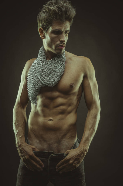Элегантный и мускулистый мужчина с обнаженным туловищем и цепями
   - Фото, изображение